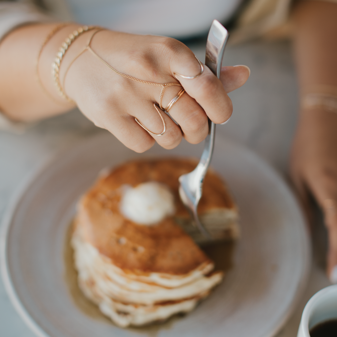 Gold ring stack featuring statements rings, simple stacking rings, and a chain ring by Hello Adorn.