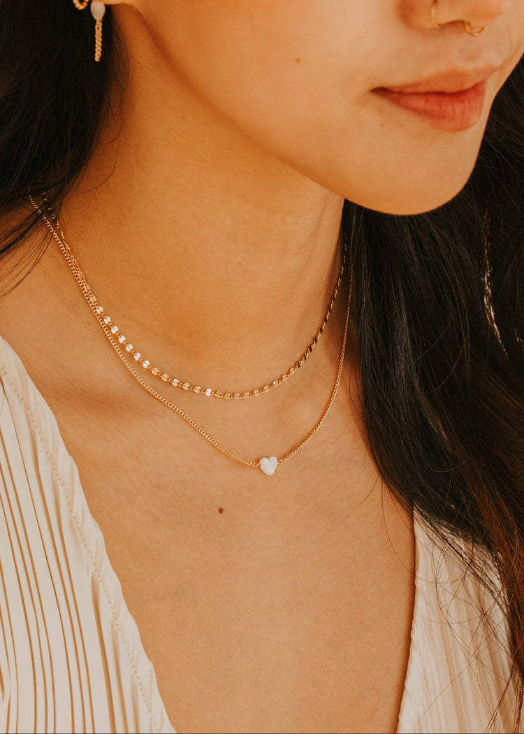 Close-up of a woman wearing gold jewelry with a blurred background