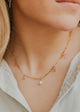 Close-up image of a stylish charm necklace featuring delicate charms and a shiny chain, perfect for adding a personalized touch to any outfit.