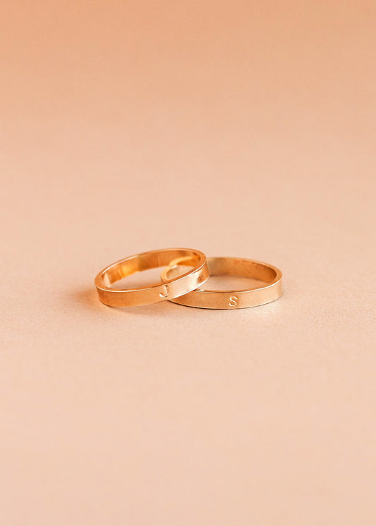 Two gold rings on a beige background