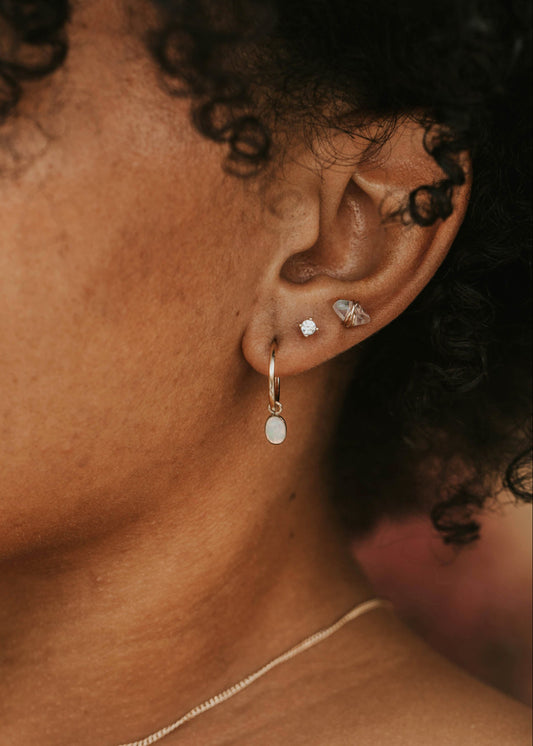 Close-up of an ear with earrings and a necklace