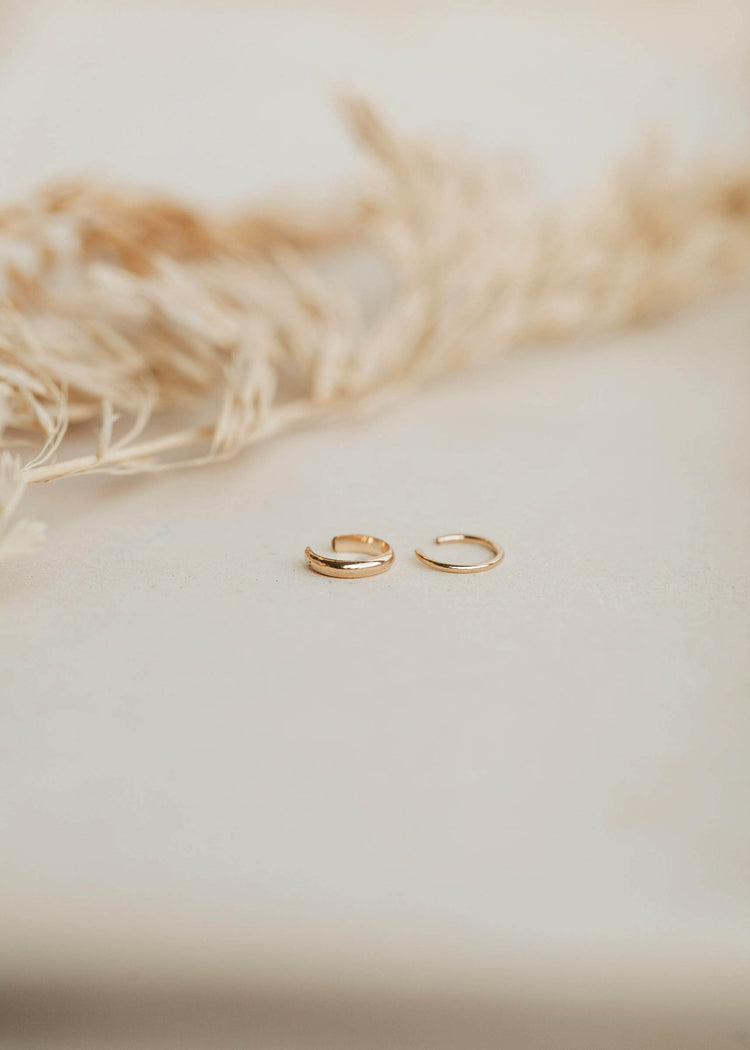 A thick ear cuff and a thin ear cuff sold as a pair in the Ear Cuff Duo by Hello Adorn which features a pair of ear cuffs as without piercing earrings.