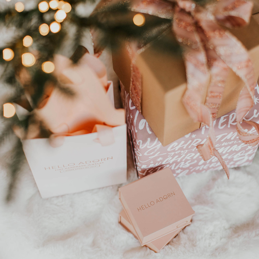 Hello Adorn wrapped gifts under a tree.