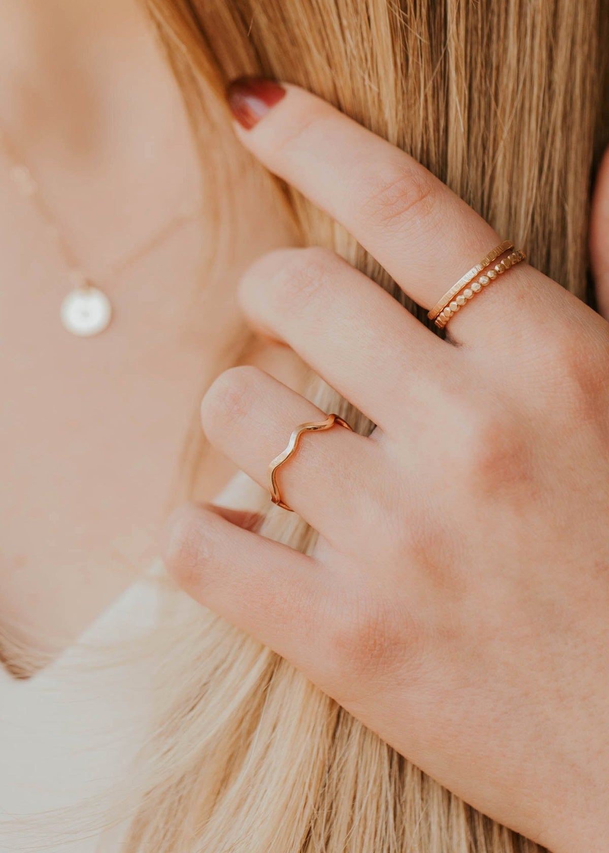 Close-up of a person wearing gold rings on a blurred background