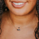 Two gemstone necklaces layered, part of the gemstone jewelry collection from Hello Adorn, a stone necklace with a labradorite black stone attached to a gold chain.