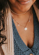 Close-up image of a stylish charm necklace featuring delicate charms and a shiny chain, perfect for adding a personalized touch to any outfit.