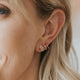 Spiral hoop earrings shown styled with moonstone stud earrings by Hello Adorn.