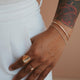 A jewelry idea featuring a Tides Cuff created from a simple cuff bracelet with a chain bracelet attached and styled and styled with a ring stack featuring a statement ring in Supermoon Ring, a gemstone ring, and a thin ring from Hello Adorn.