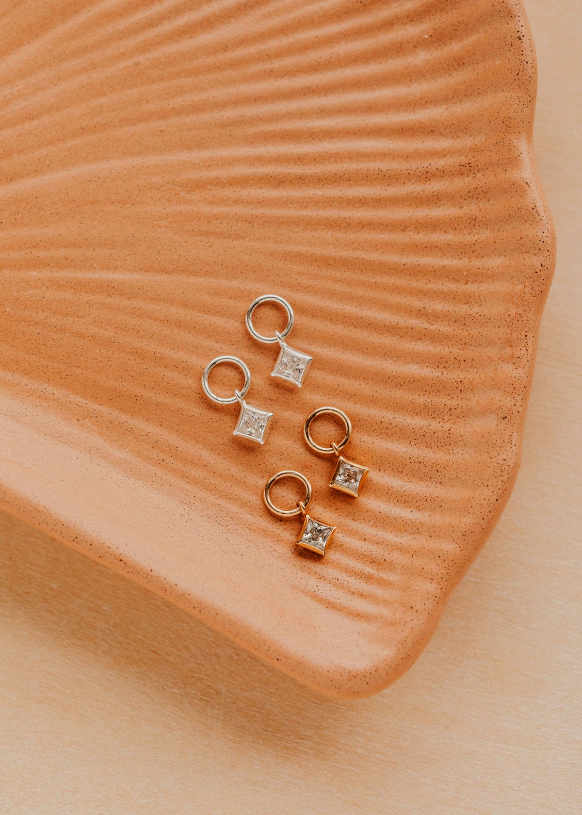 14K Gold Fill and Sterling Silver Grace Charms by Hello Adorn - CZ star charms on huggies on ceramic dish
