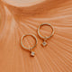 14K Gold Fill Grace Hoops by Hello Adorn - pair of gold huggies with CZ star charms on ceramic dish