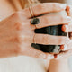 Person holding a black mug with a blurred background