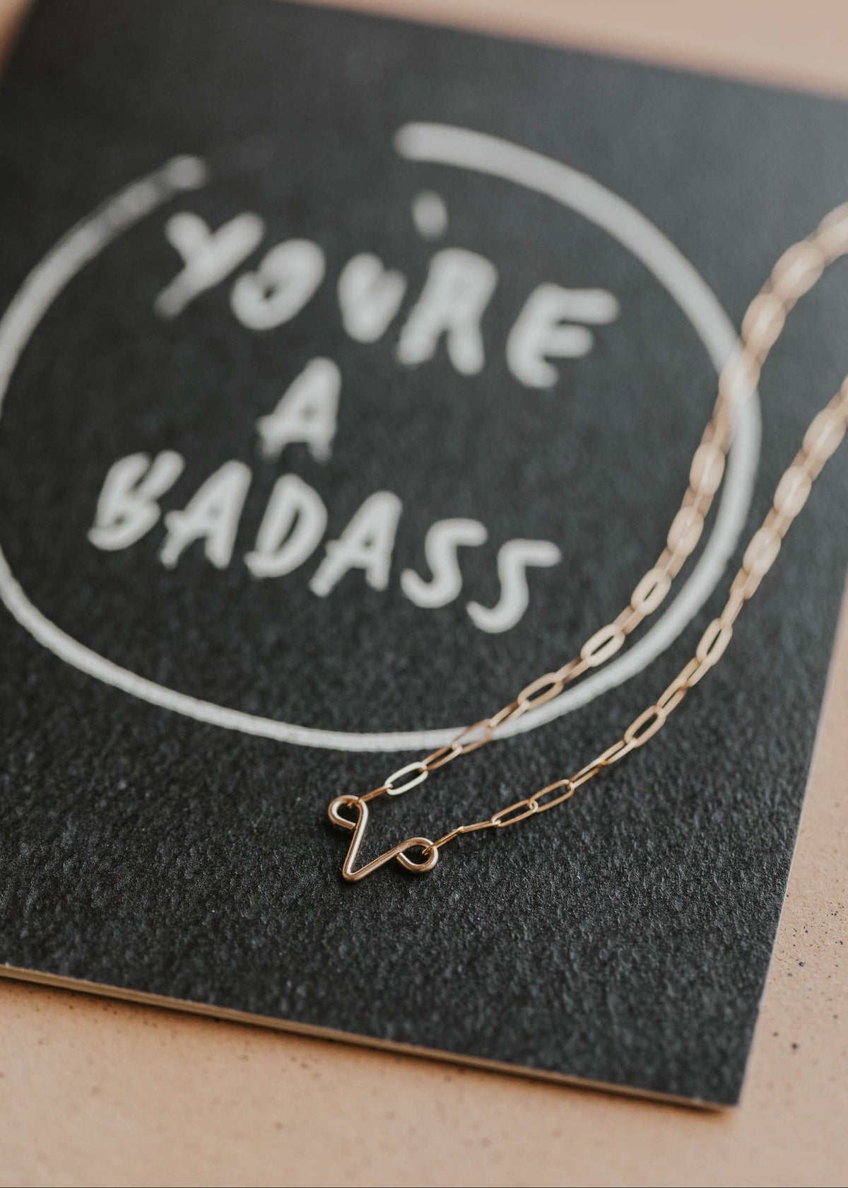 you're a badass card with uterus necklace flat lay