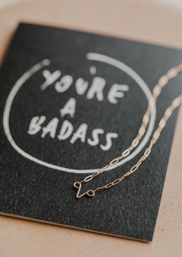 you're a badass card with uterus necklace flat lay