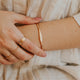 14K Gold Fill Signet Cuff by Hello Adorn - worn on model's wrist with initial band ring and delicate chain bracelets