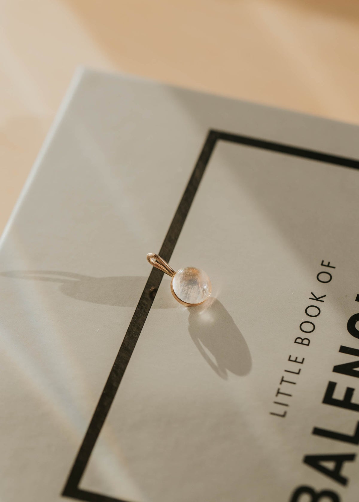 Gold pendant on a Balenciaga book