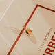 Gold tigers eye pendant sitting on a Burberry book
