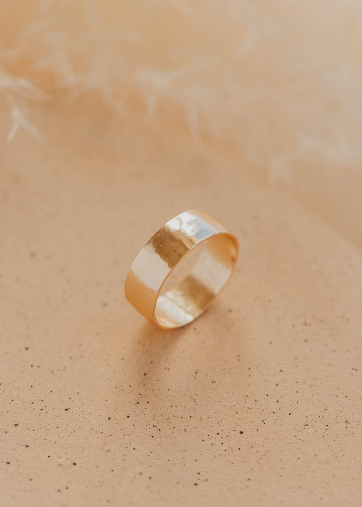 Gold ring on a soft beige background