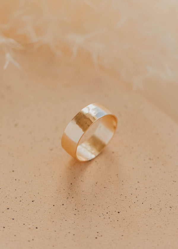 Gold ring on a soft beige background