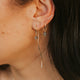 Close-up of an ear with multiple earrings against a blurred background