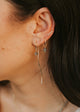 Close-up of an ear with multiple earrings against a blurred background