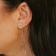 Close-up of a person wearing gold earrings with dark hair.
