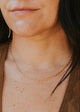 Close-up of a person wearing a gold chain necklace.