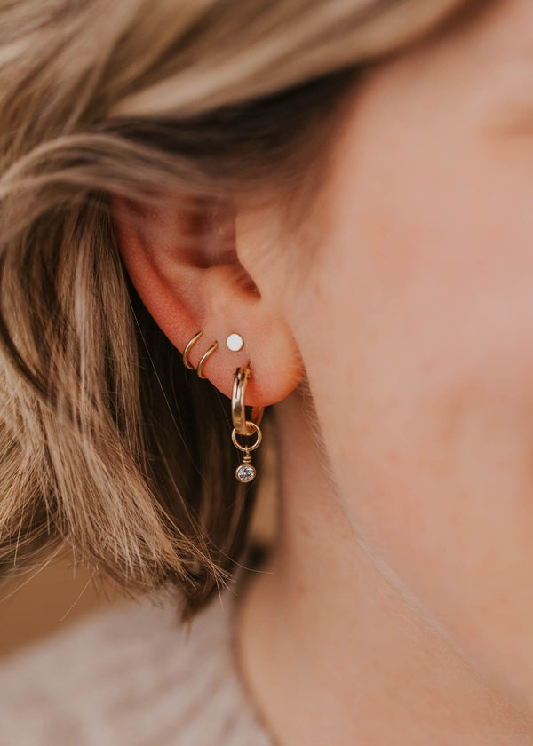 sparkly hoop charm earring styled on modell with tiny twist earrings