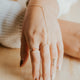 Beaded ring used to create a ring stack in 14k gold fill styled with a hand chain, above the knuckle ring, and a gemstone ring by Hello Adorn. 