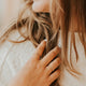 Gold Teeny-Tiny stackable ring being held, styled with a textured ring to create a ring stack by Hello Adorn.