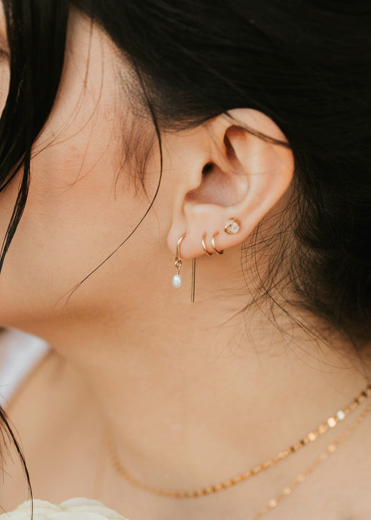 Close-up of a person wearing earrings with a soft focus on the background