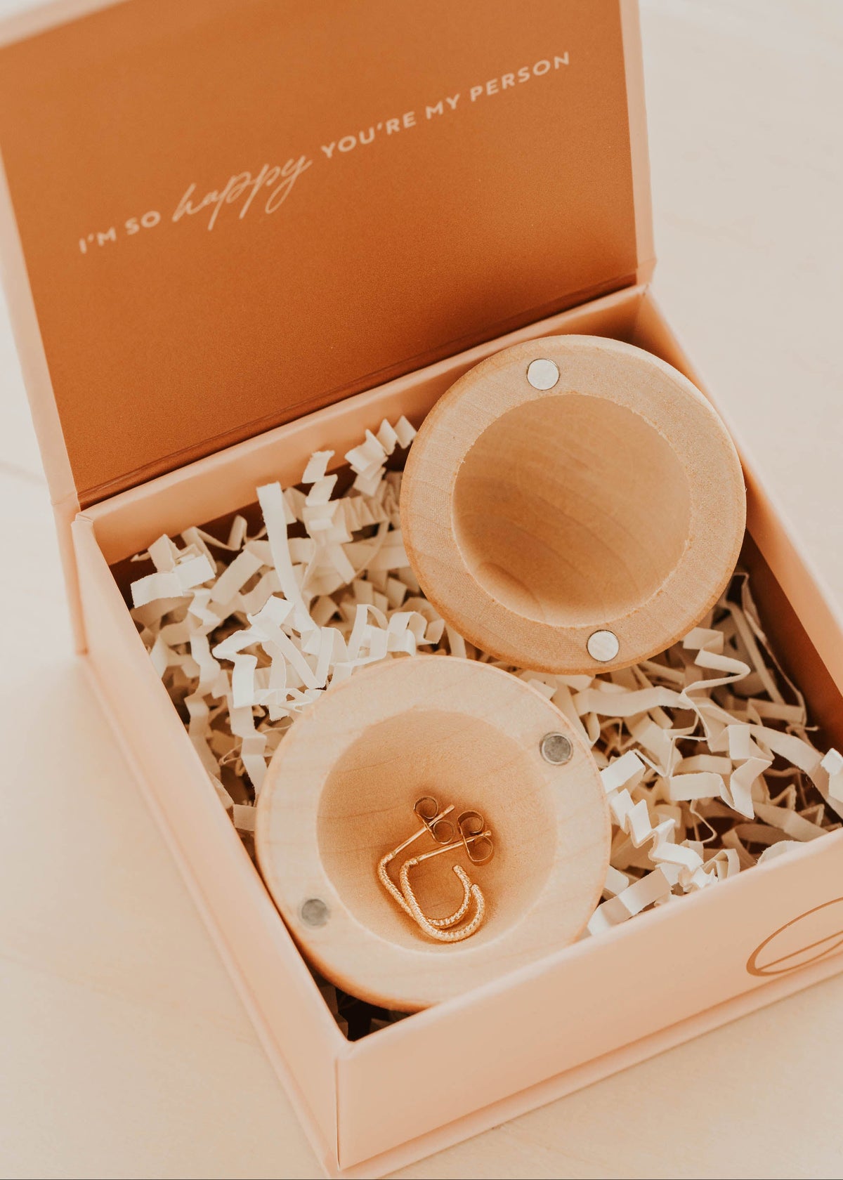 Wooden egg-shaped box with gold earrings