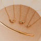 Gold necklaces on a beige surface