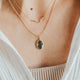 Close-up of a person wearing a delicate necklace with a small pendant.