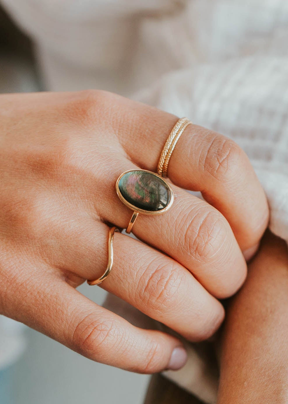Close-up of two hands holding each other with visible jewelry.