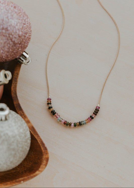 Necklace with multicolored beads on a light wooden surface