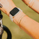 Person wearing a smartwatch with multiple bracelets on a blurred background