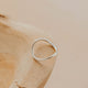 Silver ring on a wooden surface with a neutral background