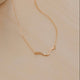 Gold necklace on a beige surface
