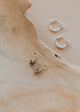 Three pairs of earrings on a wooden surface