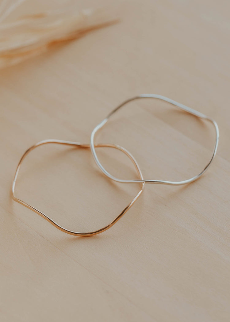 Gold and silver bracelets on a beige surface