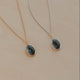 Two necklaces with pendant stones on a beige background