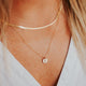 Gold initial necklace by Hello Adorn styled with herra layering chain.