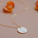 A body positive necklace charm of a hand-stamped feminine silhouette outline on a 14kt Gold Fill disc pendant.