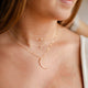 A 3 layered necklace set styled with a mini-moon crescent moon necklace, a stone necklace, and a pearl necklace all handmade by Hello Adorn, pendants and stones are attached to a dainty chain necklace.