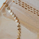 A 14kt Gold Fill clasp bracelet with round discs linked together.