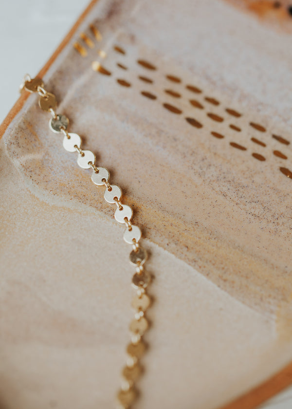 A 14kt Gold Fill clasp bracelet with round discs linked together.