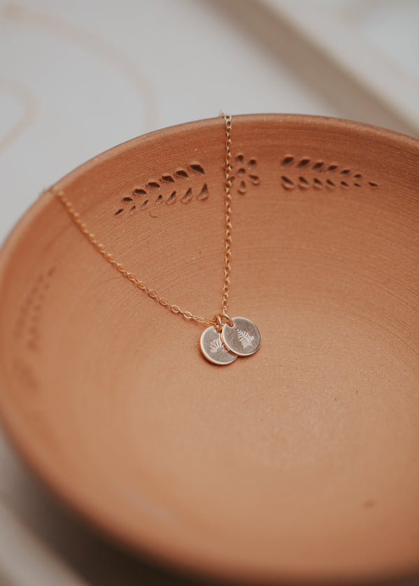 A custom necklace with symbols stamped on jewelry handmade by Hello Adorn, a staple necklace to add to any necklace layering or wear as a statement necklace.