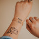 A model styling two 14kt Gold Fill bracelets featuring a double rope chain bracelet with minimal link chain bracelet.