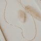 A layering necklace in 14k gold fill with linked chains which is one type of gold link chains Hello Adorn offers in their layering chain collection.