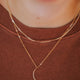 Two layered necklaces in gold, a moon necklace with a mini-moon attached to the bottom of the dainty chain styled with the Mari chain necklace shown in 14k gold fill designed and handmade by Hello Adorn.